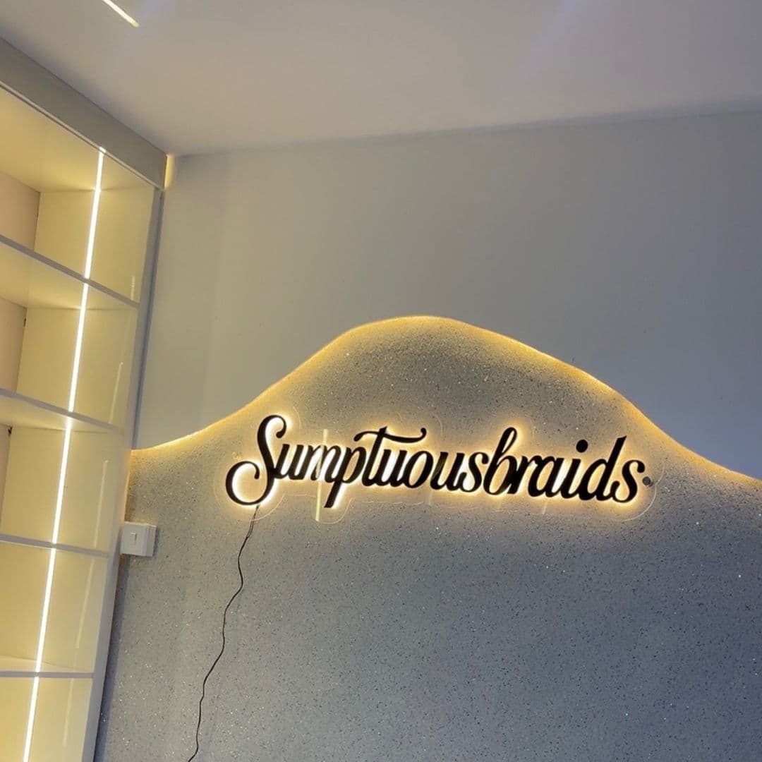 The illuminated Sumptuous Braids sign in the salon