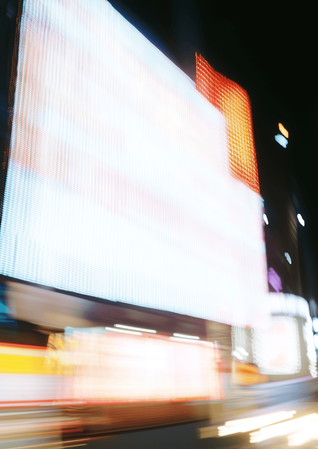 Illuminated billboards on a city street at night